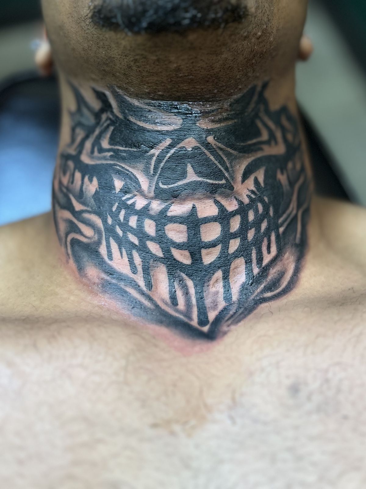 Skull-style neck tattoo