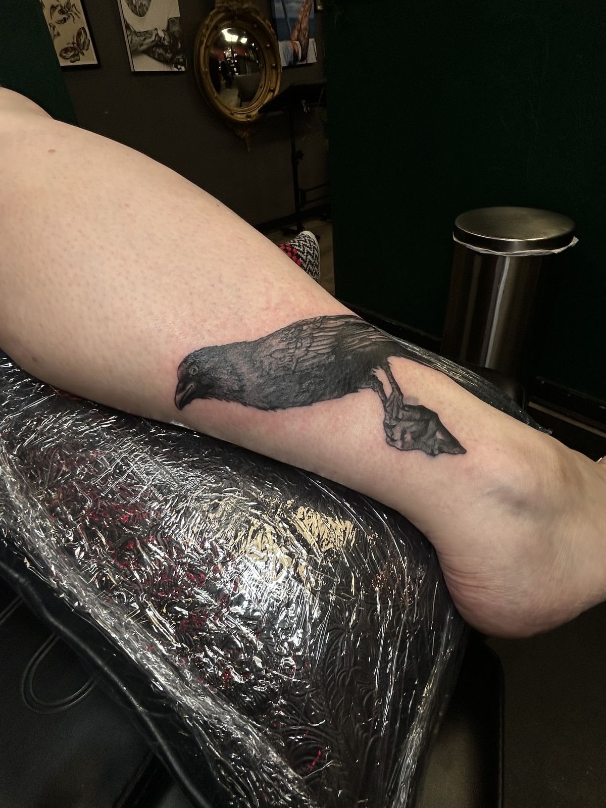 Crow with arrowhead tattoo on the ankle